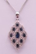A 9 ct white gold, diamond and sapphire pendant on a 9 ct white gold chain.