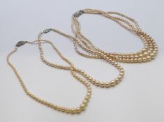 Three single strand pearl necklaces and one three strand pearl necklace.