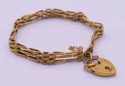 A 9 ct gold gate bracelet with heart padlock. 17 cm long. 6.7 grammes.