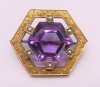 A 9 ct gold, amethyst and seed pearl brooch. 3 cm wide. 8.6 grammes total weight.