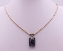 A silver and amethyst pendant on a chain. Pendant 3 cm high, chain 48 cm long.