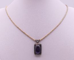A silver and amethyst pendant on a chain. Pendant 3 cm high, chain 48 cm long.