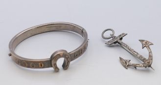 An unmarked silver good luck horseshoe bangle/bracelet and an anchor brooch. Anchor brooch 5.