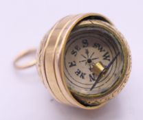 A 9 ct gold fob compass. 2 cm high 3.8 grammes total weight.