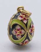 A silver gilt and enamel egg pendant. 2.5 cm high.