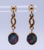 A pair of 14 K gold and opal earrings, each 3 cm high. 4.5 grammes total weight.