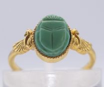An antique 14 K gold Egyptian Revival ring set with a turquoise scarab and a wing to each shoulder.