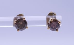 A pair of gold and diamond champagne-coloured ear studs. Approximately 0.50 carats each.