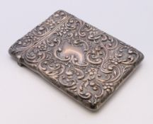 A silver card case with embossed scroll and floral decoration. 10 x 7.5 cm.