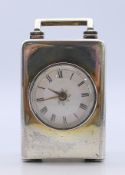 A small silver carriage clock, the movement stamped Gillett Hadlow. 6.5 cm high excluding handle.