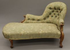 A Victorian button-upholstered walnut chaise lounge. 150 cm long.