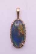 A 14 ct gold and black opal doublet pendant. 2.5 cm high including suspension loop.