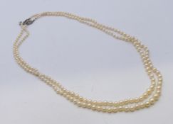 A double strand pearl necklace with an unmarked 18 ct gold, platinum and diamond clasp. 58 cm long.