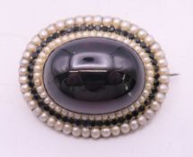 A Victorian unmarked gold, amethyst and seed pearl cabochon brooch,