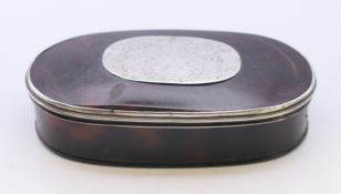 An 18th century tortoiseshell oval snuff box with engraved silver armorial plaque with the motto
