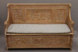 A Victorian limed carved oak settle. 153 cm long.