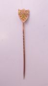 A 9ct gold shield shaped stick pin. 5 cm high. 0.6 grammes.