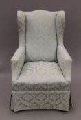 An Edwardian teal upholstered armchair. 68 cm wide.