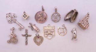 Thirteen silver charms, to include: a penguin, grand piano, penny farthing cyclist, totem pole,