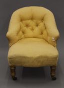 A Victorian yellow upholstered button-back armchair. 60 cm wide.