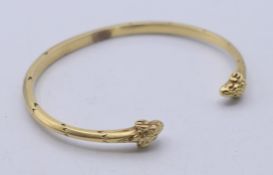 An 18 ct gold (tested) rams head bangle. 0.5 cm high, 6.5 cm internal diameter. 32.3 grammes.