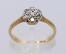 An 18 ct gold and diamond flowerhead ring. Ring size M. 2.2 grammes total weight.