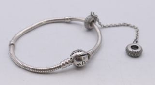 A boxed Pandora bracelet with charm. 16 cm long.