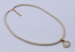 A single-strand pearl necklace with pendant. 43 cm long.