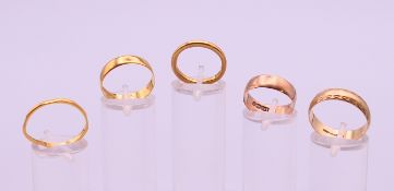 Three 22 ct gold wedding bands (9.4 grammes) and two 9 ct gold wedding bands (4.9 grammes).