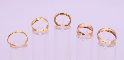 Three 22 ct gold wedding bands (9.4 grammes) and two 9 ct gold wedding bands (4.9 grammes).