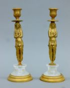 A pair of gilt bronze Egyptian Revival-style candlesticks. Each 25 cm high.