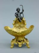 A gilt bronze cherub-mounted table salt. 18.5 cm high.