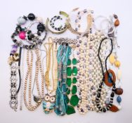 A quantity of costume jewellery including bangles, brooches and necklaces.