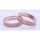 Two silver engraved bangle-form bracelets. Each 5.5 cm inner width. 53.3 grammes.