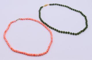 A jade bead necklace and a coral bead necklace with a 9 ct gold clasp. The latter 42 cm long.
