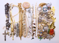 A quantity of various costume jewellery, including brooches, necklaces and a crucifix pendant.