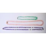 A rose quartz necklace, an amethyst necklace and a jade necklace. The latter 39 cm long.