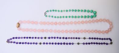 A rose quartz necklace, an amethyst necklace and a jade necklace. The latter 39 cm long.