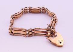 A 9 ct gold gate bracelet with padlock clasp. 18 cm long. 13.9 grammes.
