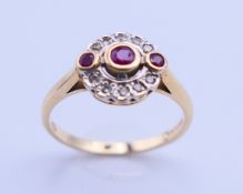 A 14 ct gold, ruby and diamond target ring. Ring size Q/R. 3.3 grammes total weight.
