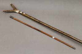A silver-topped swagger stick and an antler-handled walking stick. The latter 154 cm high.