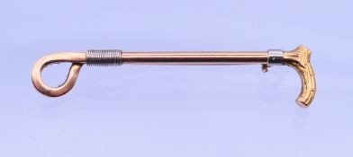 A 14 ct gold brooch formed as a riding crop, inscribed Connie 19.11.41. 4.75 cm long. 3.8 grammes.