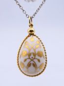 A Franklin Mint porcelain easter egg pendant on a sterling silver chain.