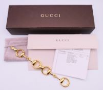 An 18 ct gold Gucci horsebit bracelet in maker's fitted box with original invoice and papers.