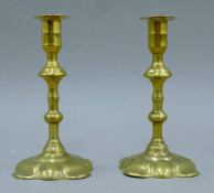 A pair of 18th century brass petal-based candlesticks. Each 19 cm high.