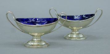 A pair of Victorian silver salts with blue glass liners. Each 10.5 cm wide. 93.8 grammes.