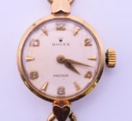 A 9 ct gold ladies Rolex wristwatch on a rolled gold strap. 2 cm diameter. 12.