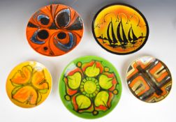 Five Poole Pottery mid century modern plates and shallow bowls including Delphis and Aegean