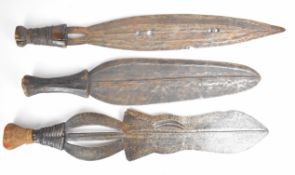 Three tribal knives, all with wooden handles and wide blades, longest blade 43cm. PLEASE NOTE: WE