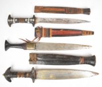 Three tribal knives, all with leather covered sheaths, longest blade 26cm. PLEASE NOTE: WE ARE NOT